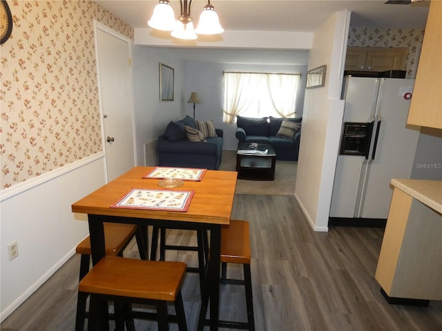 dining space featuring dark wood-type flooring and a notable chandelier