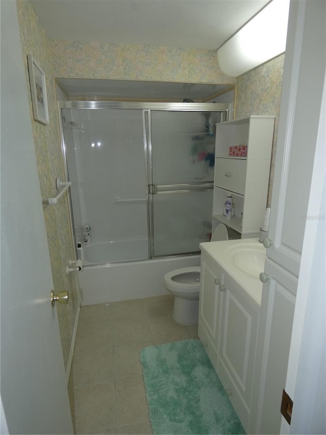 full bathroom with tile patterned floors, vanity, toilet, and shower / bath combination with glass door