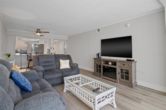 living room with ceiling fan, a fireplace, and hardwood / wood-style flooring