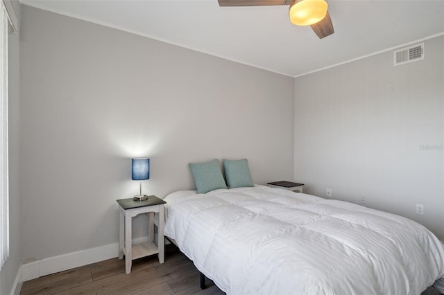 bedroom featuring ornamental molding, ceiling fan, and dark wood-type flooring