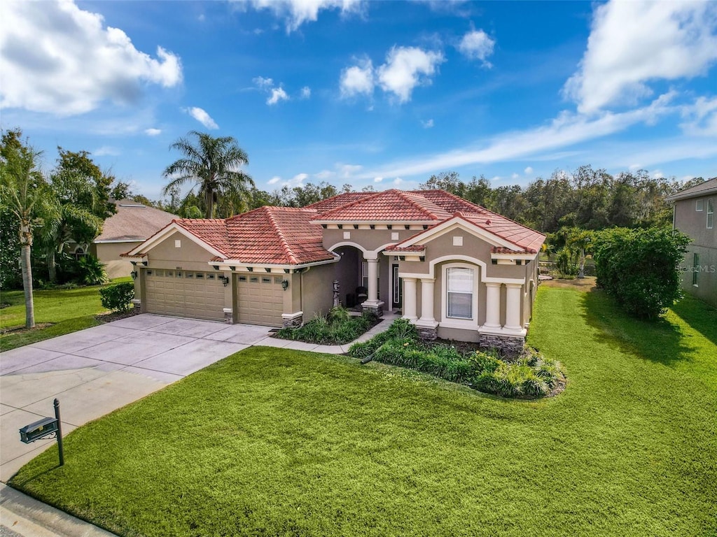 mediterranean / spanish home with a front yard and a garage