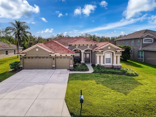 mediterranean / spanish house featuring a garage and a front lawn