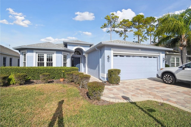 ranch-style house with a garage and a front lawn