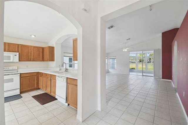 kitchen with white appliances, sink, vaulted ceiling, ceiling fan, and light tile patterned floors