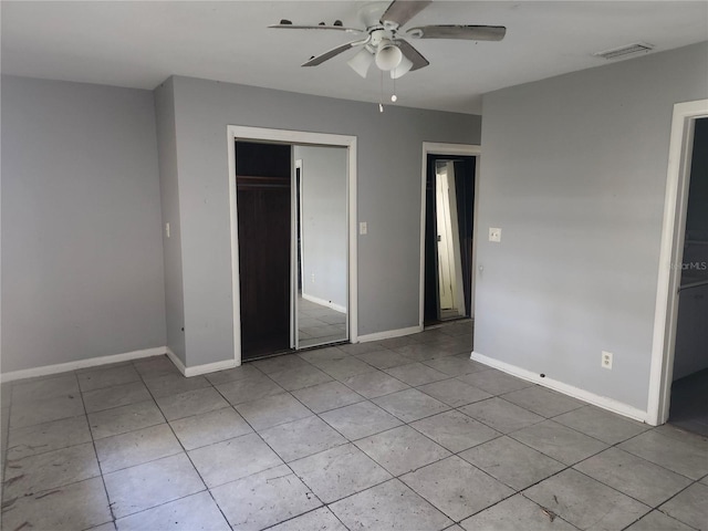 unfurnished bedroom with a walk in closet, ceiling fan, a closet, and light tile patterned flooring