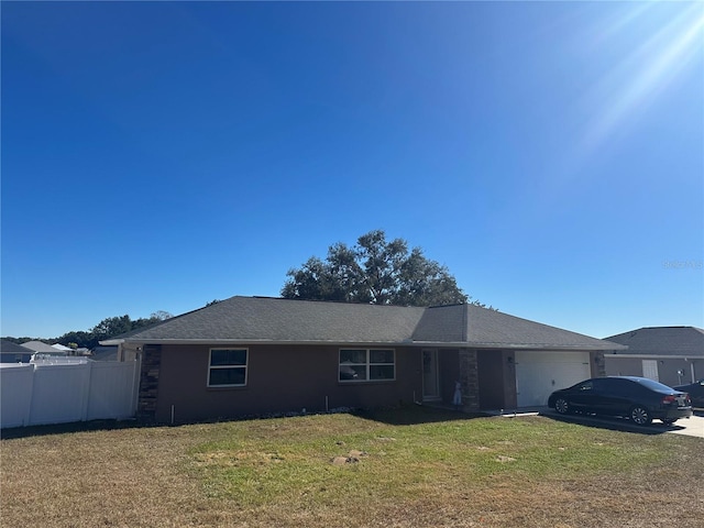 ranch-style home with a garage and a front lawn