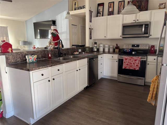 kitchen featuring pendant lighting, sink, a textured ceiling, white cabinetry, and stainless steel appliances