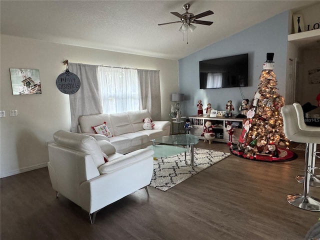 living room featuring a textured ceiling, ceiling fan, dark wood-type flooring, and vaulted ceiling