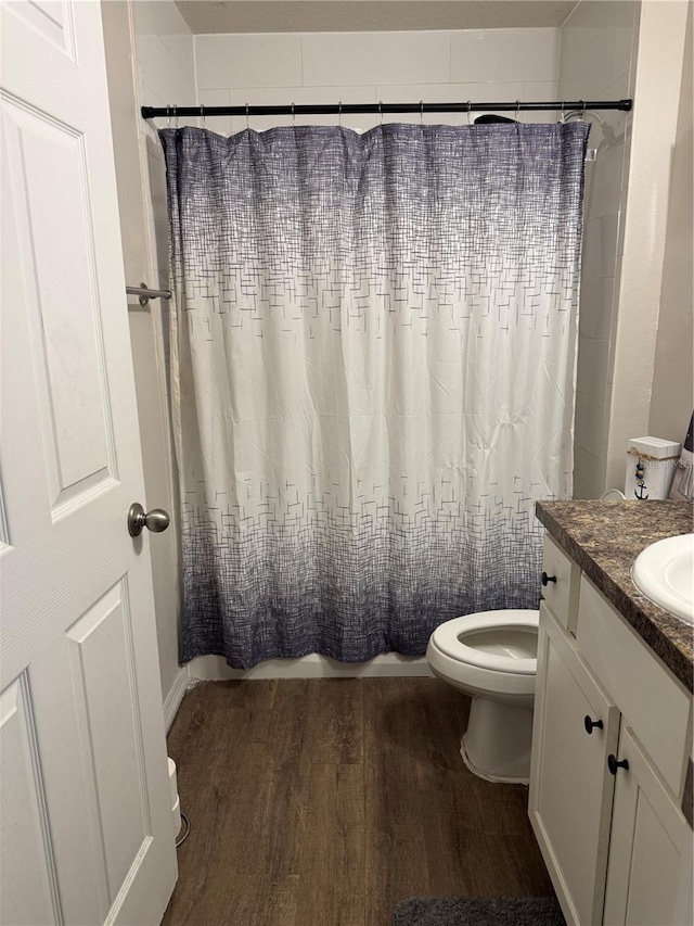 bathroom featuring toilet, hardwood / wood-style floors, vanity, and a shower with shower curtain