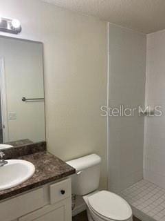 bathroom with vanity, toilet, and a shower