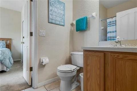 bathroom featuring tile patterned floors, vanity, and toilet