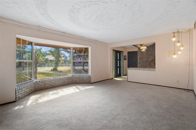 carpeted empty room with a healthy amount of sunlight and a textured ceiling