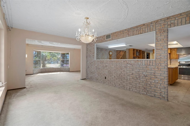 unfurnished living room featuring a textured ceiling, a notable chandelier, light carpet, and brick wall