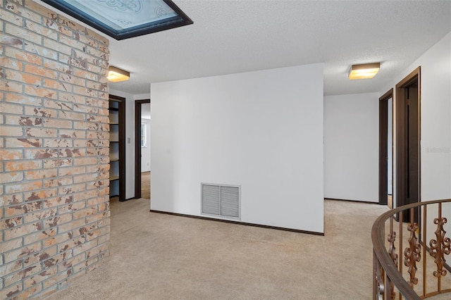 carpeted empty room with a textured ceiling