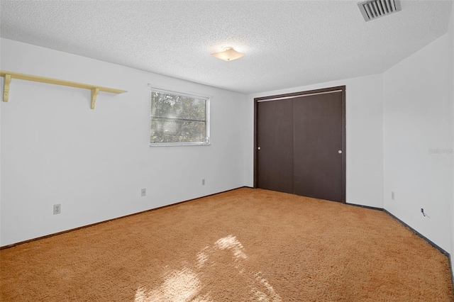 unfurnished bedroom featuring carpet flooring, a closet, and a textured ceiling