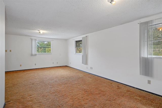 carpeted empty room featuring a textured ceiling