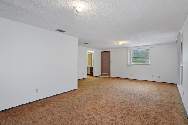 carpeted spare room featuring a textured ceiling