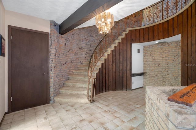 interior space featuring beam ceiling, brick wall, and an inviting chandelier