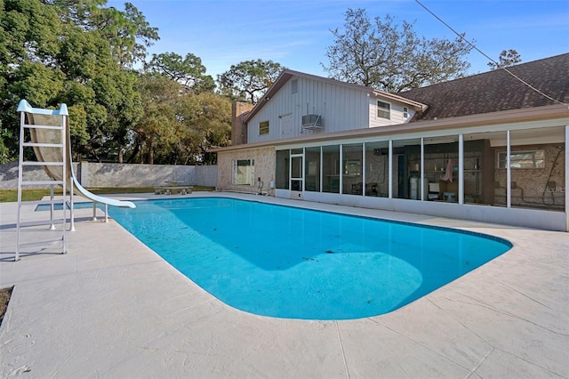 view of pool with a sunroom, a water slide, and a patio