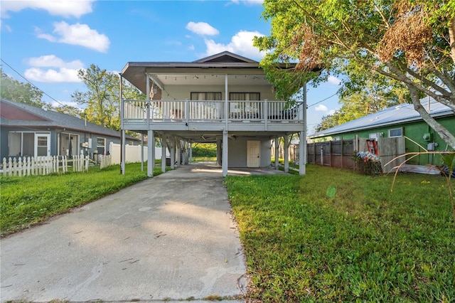 view of front of house featuring a front lawn, a balcony, and a carport