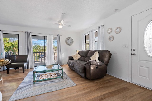 living room with wood-type flooring, a textured ceiling, and ceiling fan