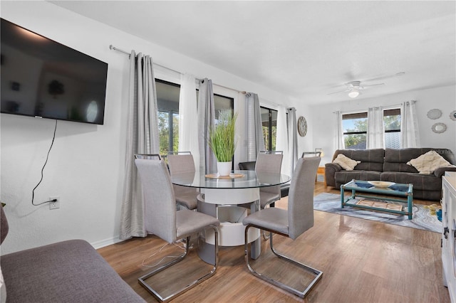 dining space with hardwood / wood-style flooring and ceiling fan