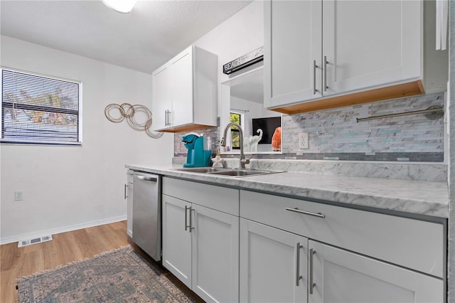 kitchen with white cabinetry, sink, stainless steel dishwasher, dark hardwood / wood-style floors, and decorative backsplash