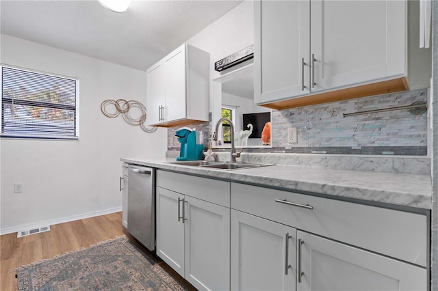 1244 31st Ave E, Bradenton, FL 34208 - kitchen featuring stainless steel dishwasher, backsplash, wood finished floors, and white cabinets
