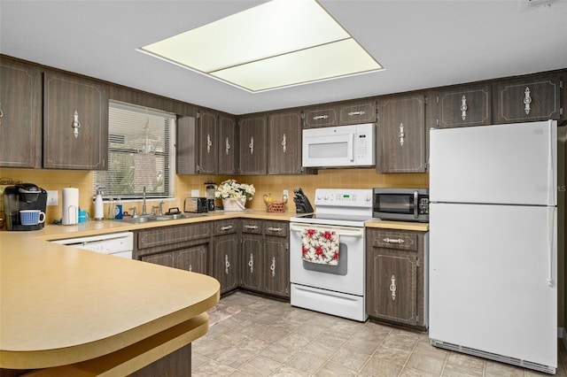 kitchen featuring tasteful backsplash, dark brown cabinets, sink, and white appliances