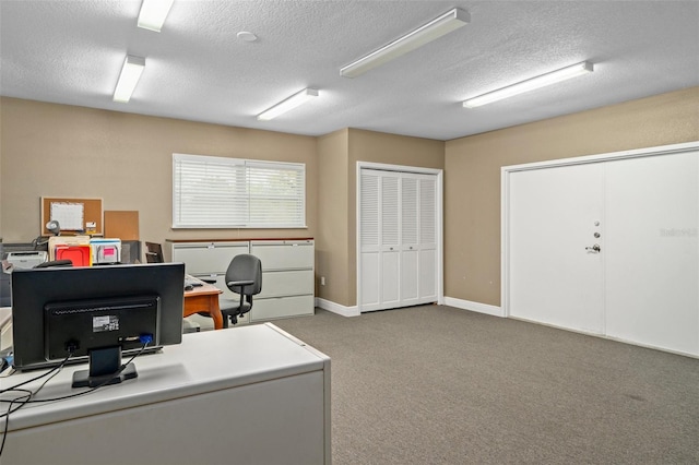 carpeted home office featuring a textured ceiling