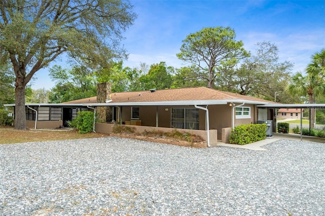 ranch-style house featuring a carport and a sunroom