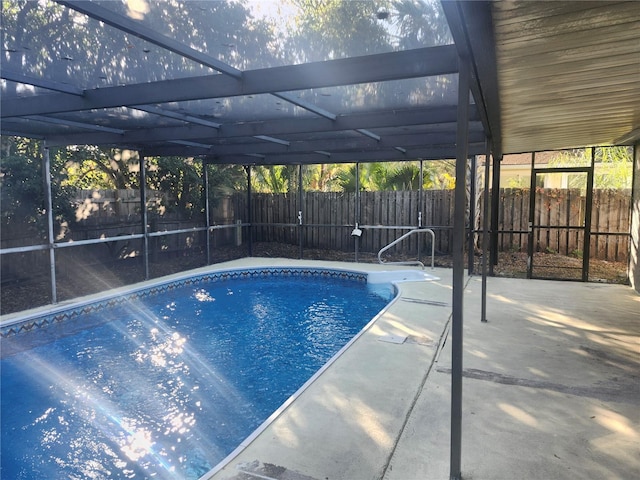 view of swimming pool featuring glass enclosure and a patio