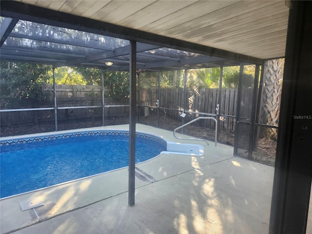 view of swimming pool featuring a patio area and glass enclosure