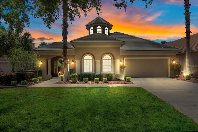 view of front facade featuring a garage and a lawn