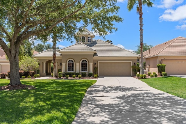 mediterranean / spanish home with a garage and a front lawn