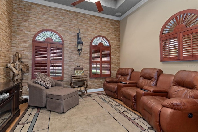 living room with a wealth of natural light, crown molding, and ceiling fan