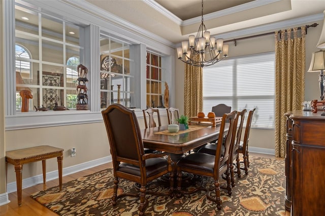 dining space with a chandelier, ornamental molding, and hardwood / wood-style flooring