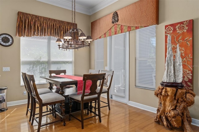 dining space featuring light hardwood / wood-style floors, an inviting chandelier, and ornamental molding