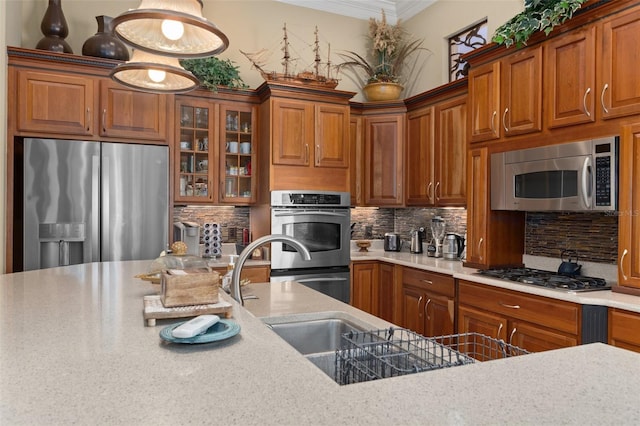 kitchen featuring decorative backsplash, appliances with stainless steel finishes, light stone counters, crown molding, and pendant lighting