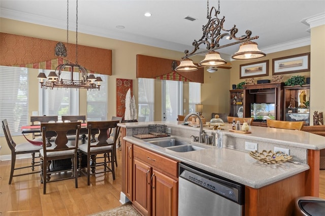 kitchen with pendant lighting, dishwasher, a kitchen island with sink, sink, and light wood-type flooring