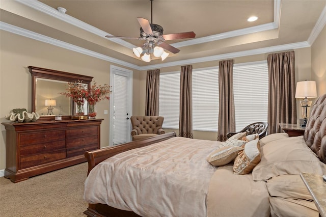 bedroom featuring ceiling fan, carpet floors, crown molding, and a tray ceiling