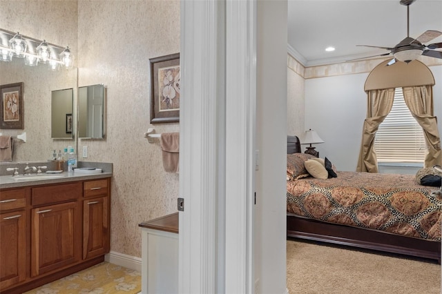 carpeted bedroom featuring ceiling fan, sink, and ornamental molding