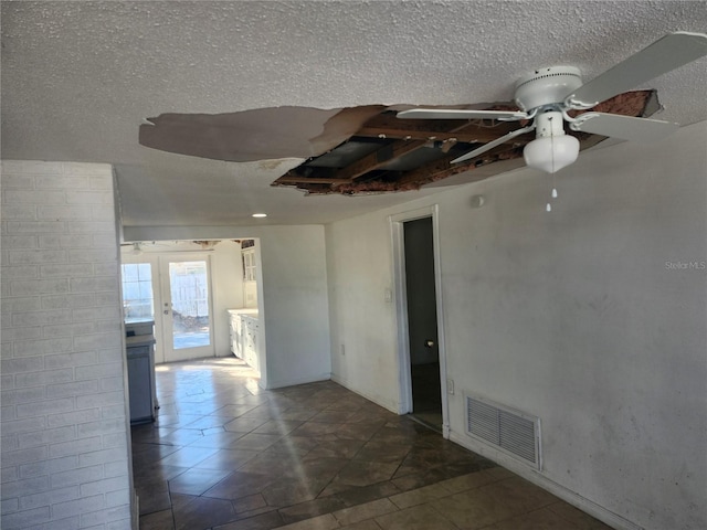 empty room featuring ceiling fan and a textured ceiling