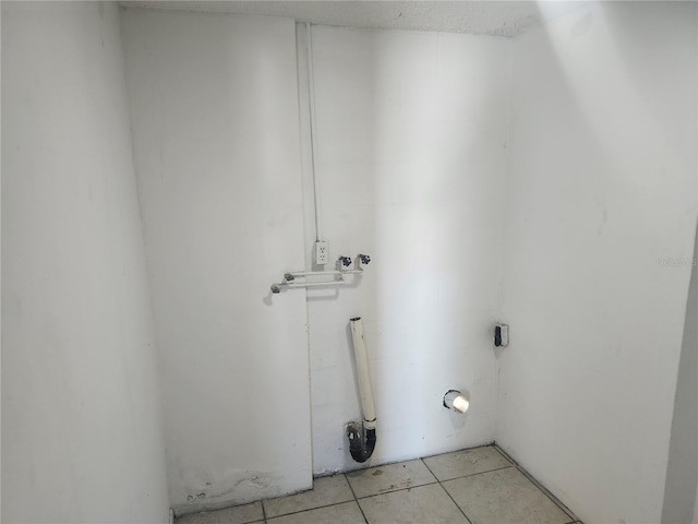 washroom with hookup for a washing machine and light tile patterned flooring