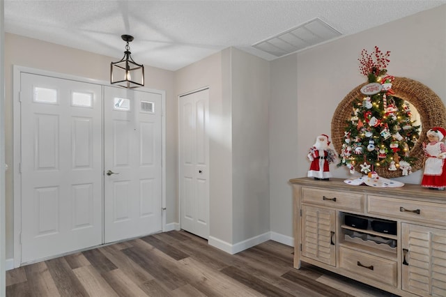 foyer with a textured ceiling and dark hardwood / wood-style floors