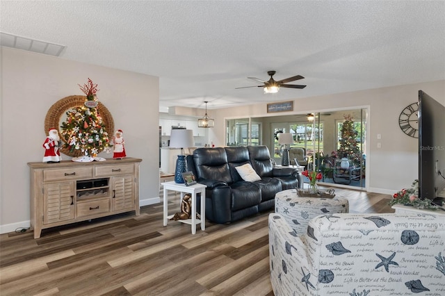 living room featuring a textured ceiling, ceiling fan, and dark hardwood / wood-style floors