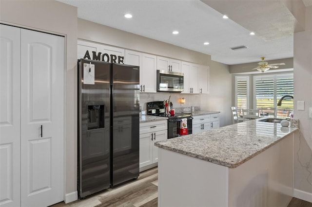 kitchen with white cabinets, light stone counters, sink, and stainless steel appliances