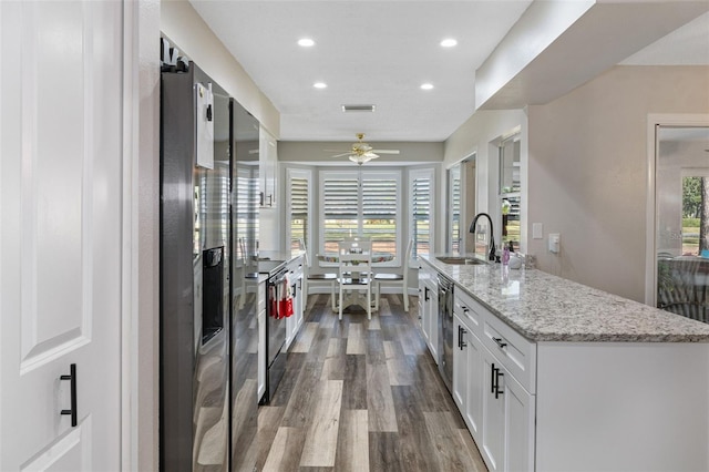 kitchen with ceiling fan, sink, electric range, light hardwood / wood-style floors, and white cabinetry