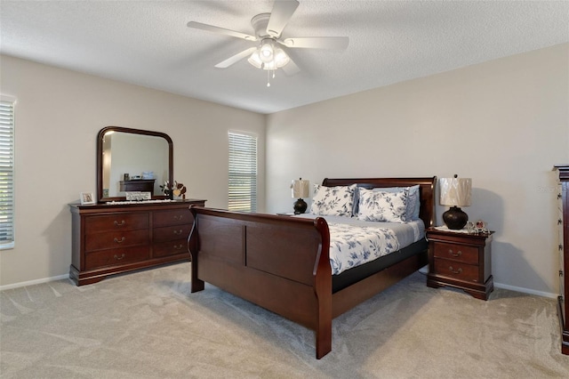 carpeted bedroom with ceiling fan and a textured ceiling