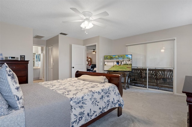 carpeted bedroom featuring ceiling fan, ensuite bathroom, and a textured ceiling